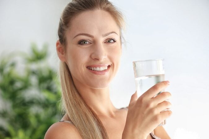 kobieta pije wodę na nawodnienie organizmu